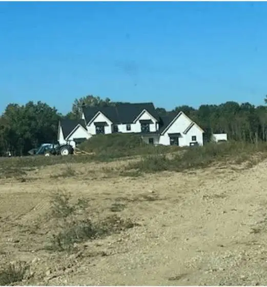 house in the background, surrounded by greenery and open space